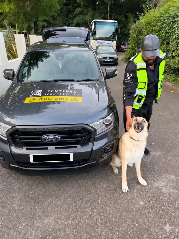 Zentinel dog handler with a German Shepherd beside the branded dog unit car